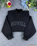 Black mock neck sweatshirt with custom dark grey Biowell embroidered lettering flat lay