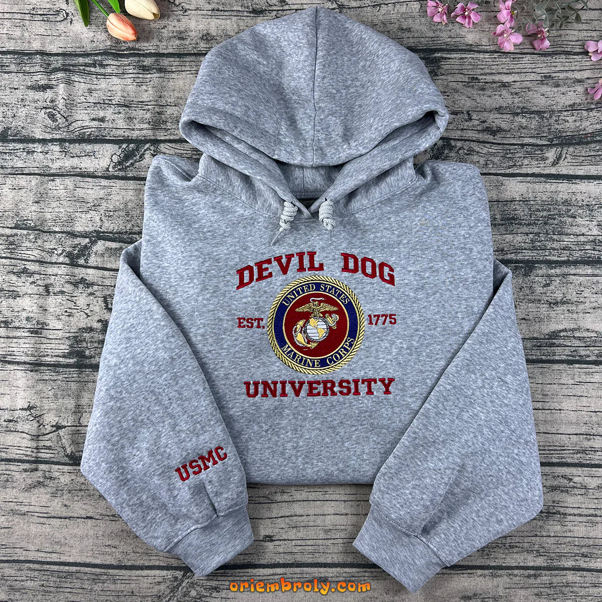 Gray hoodie with 'Devil Dog University' and USMC logo on a wooden surface.