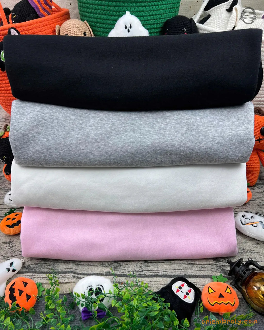 Stack of mock neck sweatshirts in black, grey, white, and pink color options
