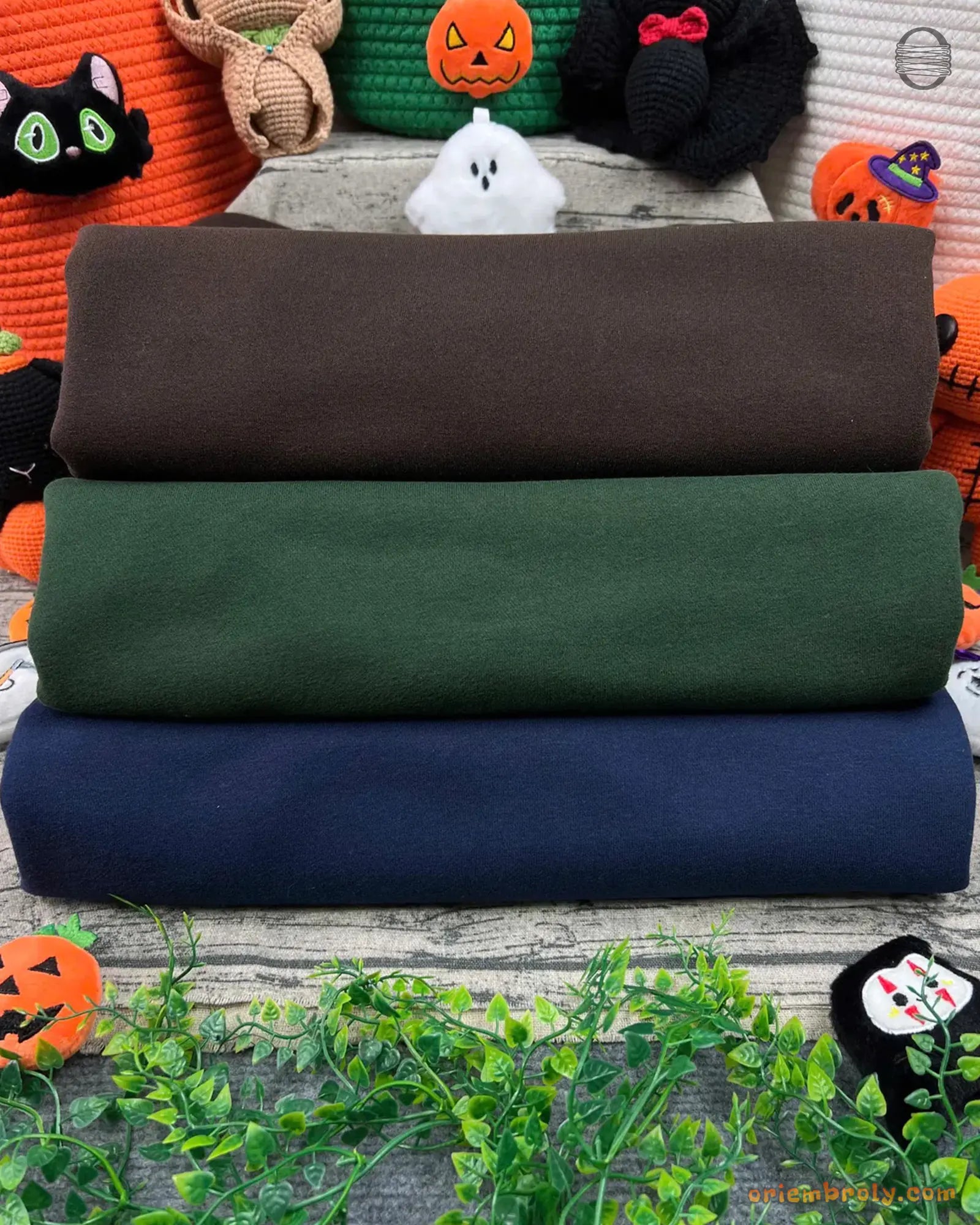 Stack of folded mock neck sweatshirts in brown, forest green, and navy blue
