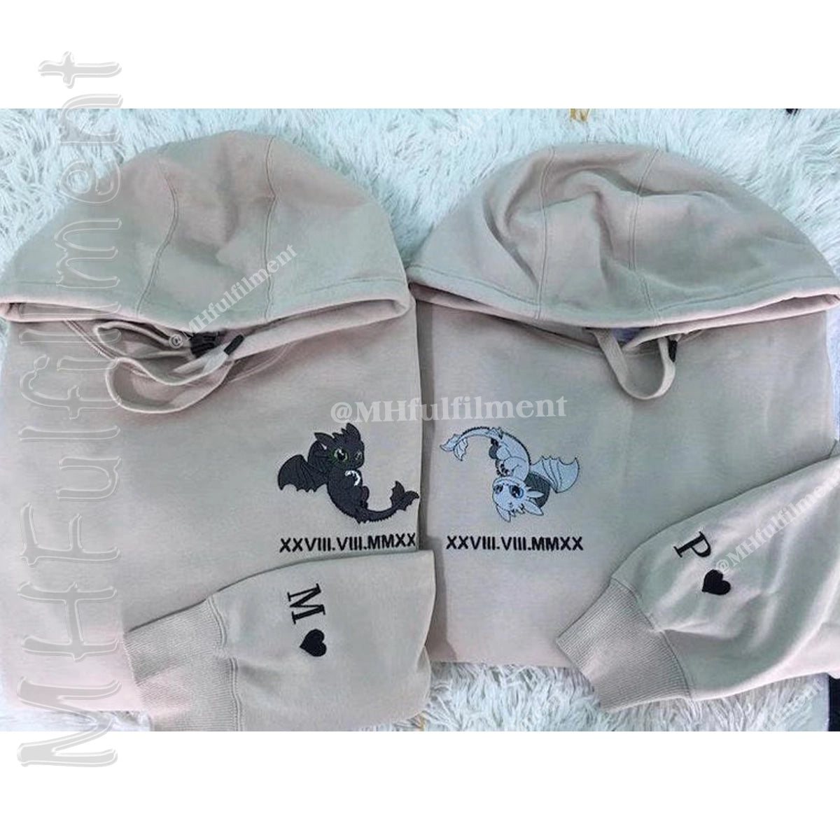 Two light gray hoodies with designs and text on a textured surface