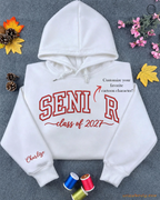 Flatlay view of a white embroidered hoodie with SENIOR Class of 2027 varsity text and custom Spider-Man sleeve name detail.