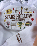 Detailed view of custom embroidered text quote on the sleeve of a white Stars Hollow Gilmore Girls sweatshirt.