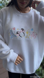 Full length view of model wearing a white embroidered Disney magical crewneck sweater for vacation outfit