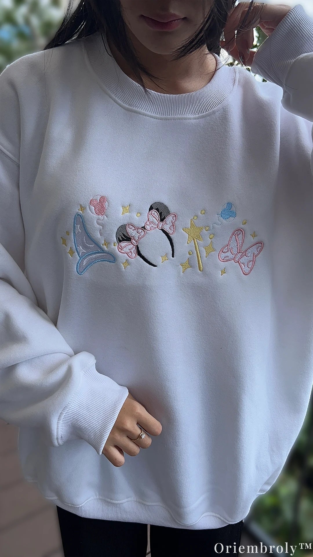 Full length view of model wearing a white embroidered Disney magical crewneck sweater for vacation outfit