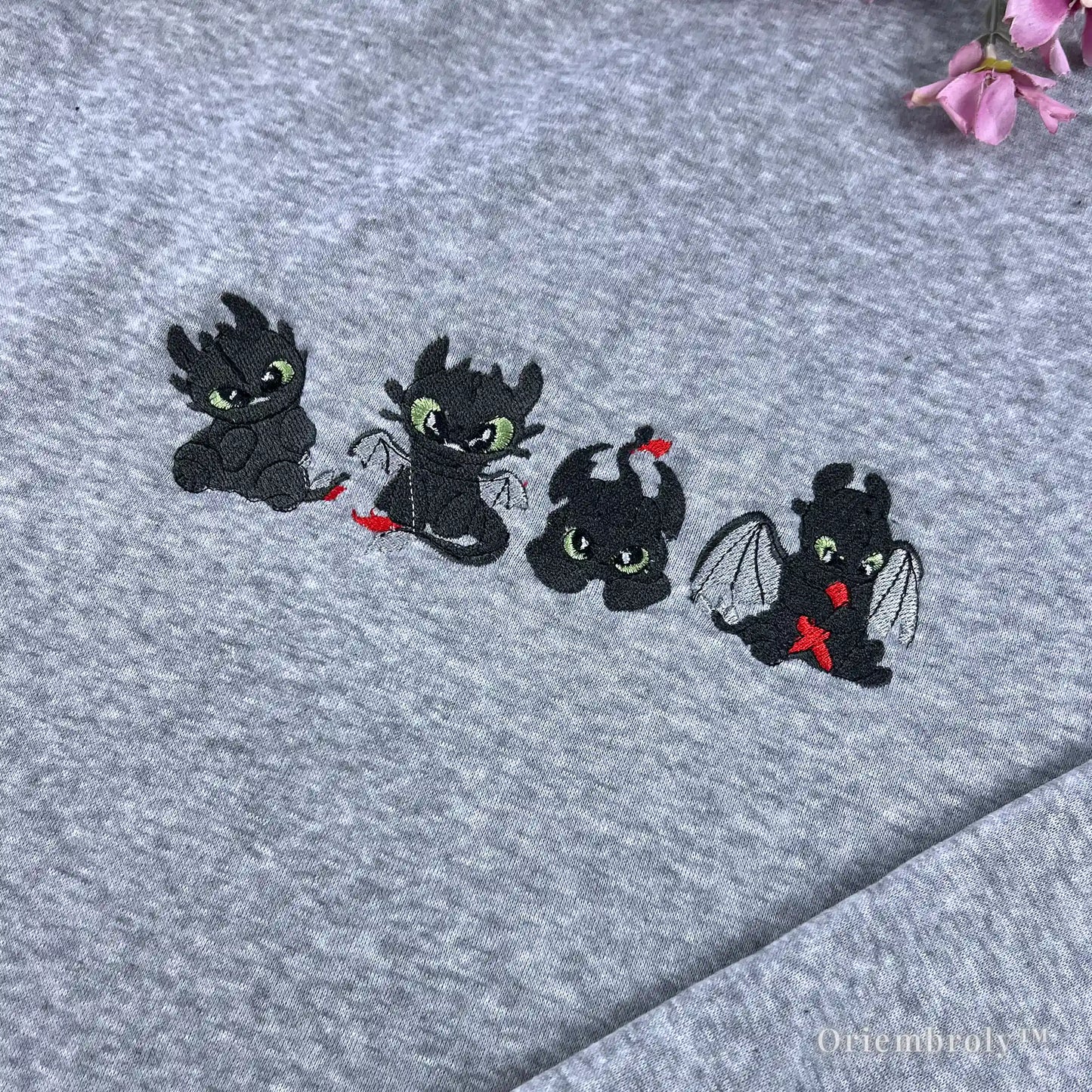 close up embroidery of cute night fury dragon with green eyes