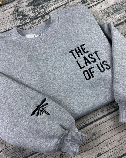 Premium black-thread embroidery of THE LAST OF US text with Firefly logo