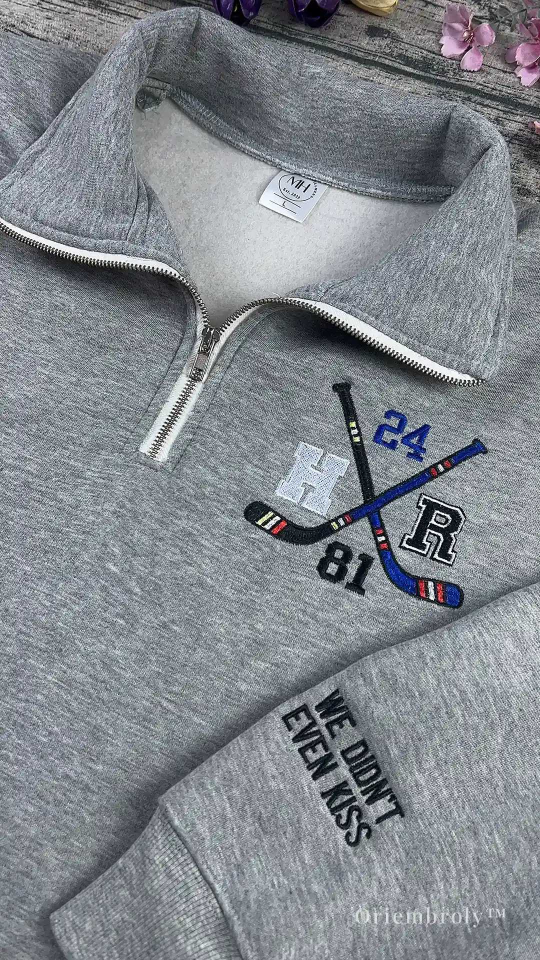 Embroidered hockey sticks and puck on pullover design