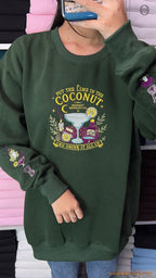 Mirror selfie of model wearing a forest green Practical Magic witchy frog embroidered crewneck sweater