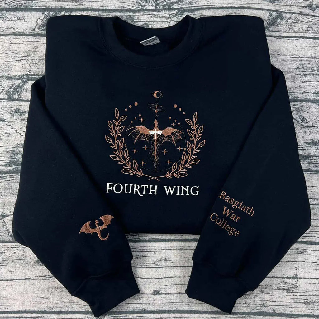 Black hoodie with 'Fourth Wing' and 'Basgalth War College' text on a wooden surface