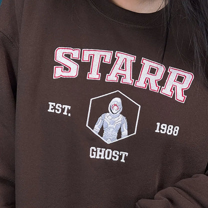 Brown sweatshirt with 'STARR' and 'GHOST' design on a person wearing it.