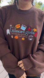 Front view try-on fit of model wearing a dark brown Gilmore Girls embroidered sweater for autumn