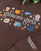 Detailed view of the custom sleeve quote embroidery and main Gilmore Girls chest graphic on a brown sweatshirt