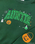 Close-up of green Auntie Halloween sweatshirt with green pattern sequin fill varsity letters, jack-o-lantern pumpkin, and potion bottle design.