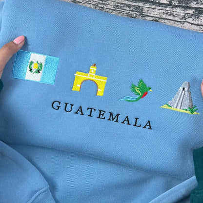Blue fabric with embroidered designs and 'GUATEMALA' text on a wooden surface