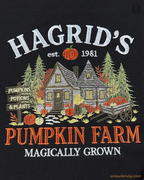 Close-up of fine embroidery on a black sweatshirt featuring Hagrid's Pumpkin Farm text, wooden cabin, pine trees, and pumpkins.
