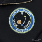 Close-up of heavyweight black quarter-zip with vibrant satin-stitched NASA-style mission patches. Durable, premium thread work designed for long-lasting comfort and style