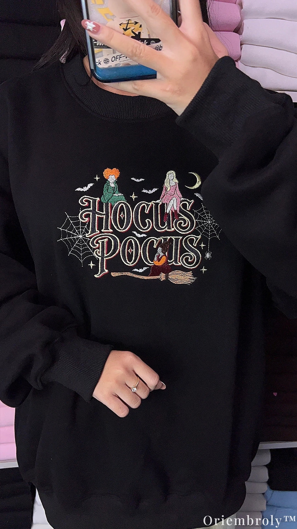 Side angle try-on photo of model wearing a black Hocus Pocus embroidered halloween sweater