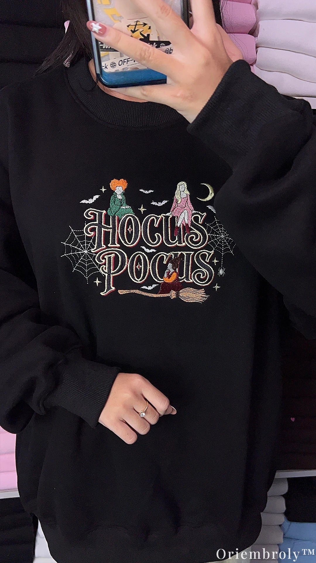 Side angle try-on photo of model wearing a black Hocus Pocus embroidered halloween sweater