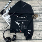 Black hoodie with bat design on a wooden surface with headphones and clapperboard.