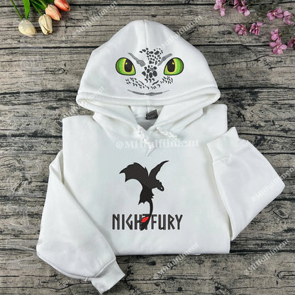 White hoodie with dragon design on a wooden surface