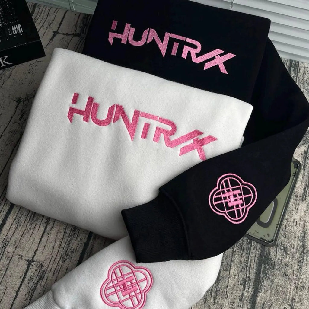 Black, white, and pink 'HUNTRX' branded items on a wooden surface