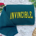 Invincible Mark superhero embroidered sweatshirt with vintage comic book style, unisex crewneck tee for fans