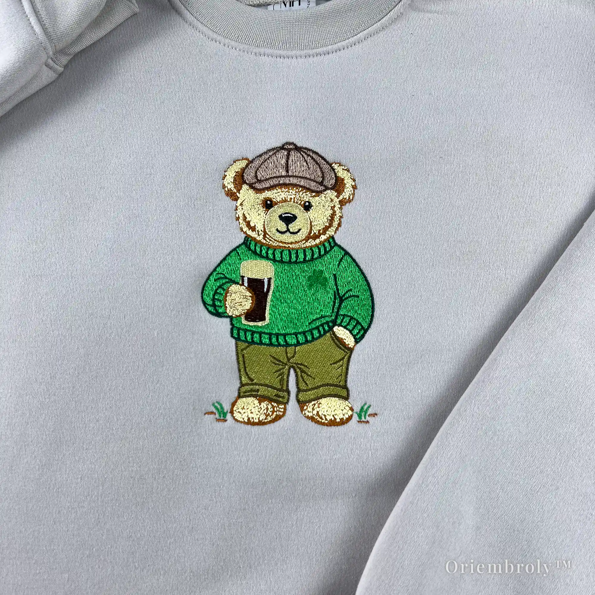 close-up embroidery of teddy bear holding stout beer