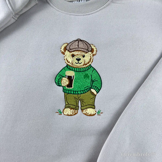 close-up embroidery of teddy bear holding stout beer