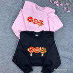 Aesthetic pink BTS sweatshirt featuring minimalist red embroidered symbols for fans
