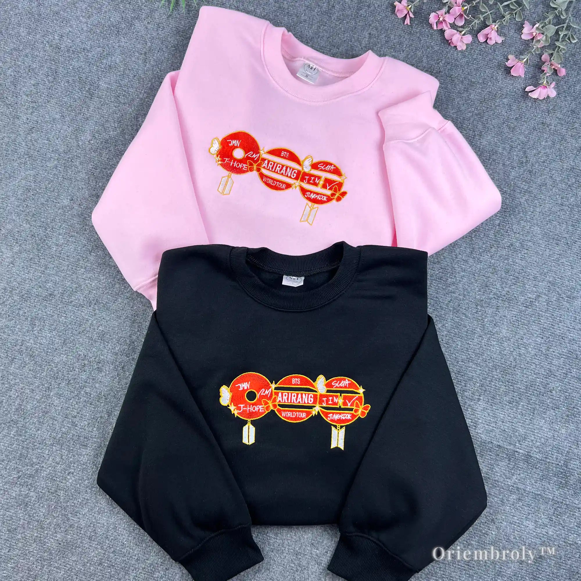 Aesthetic pink BTS sweatshirt featuring minimalist red embroidered symbols for fans