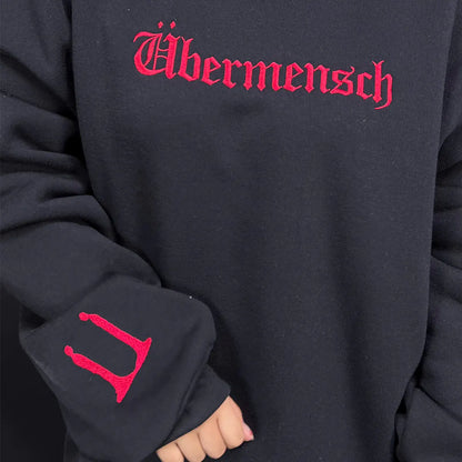 Black hoodie with red 'Ußermensch' text on a dark background