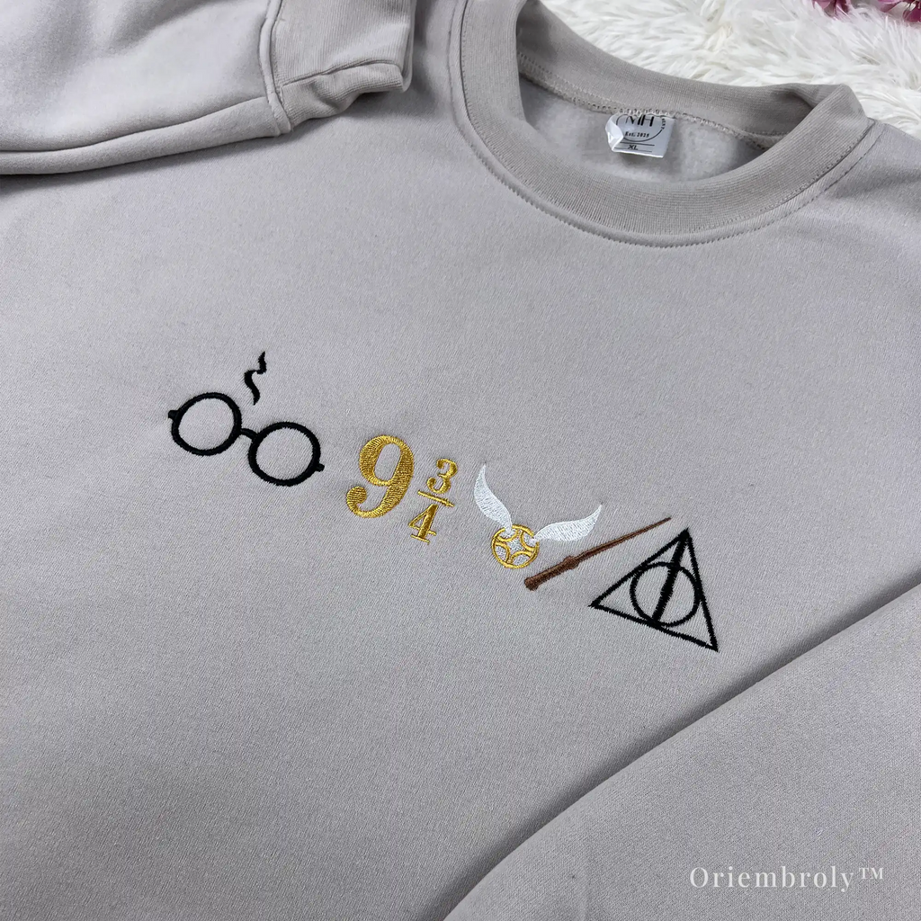 close up embroidery of wizarding symbols on sweatshirt