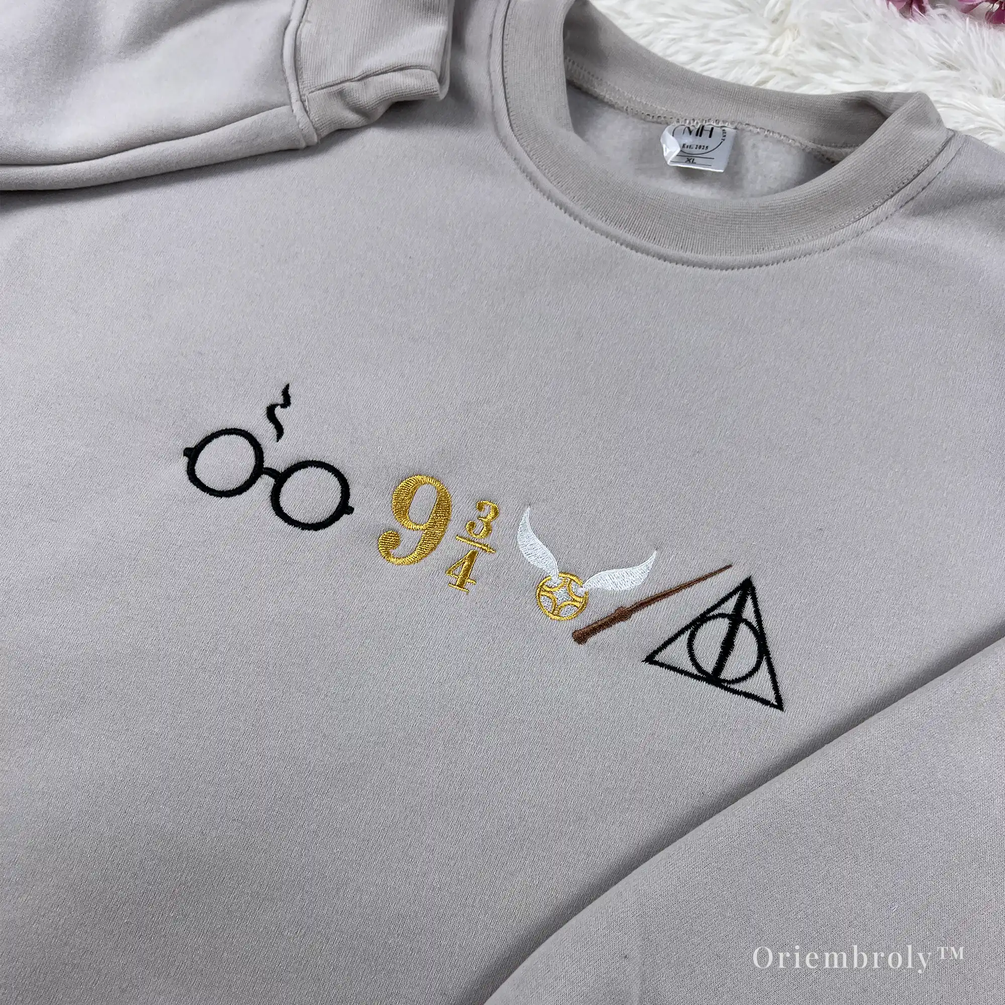 close up embroidery of wizarding symbols on sweatshirt