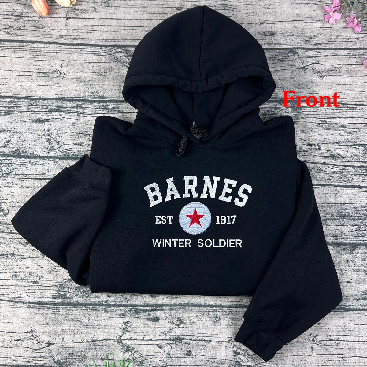 Black hoodie with 'Barnes' and 'Winter Soldier' text on a wooden surface