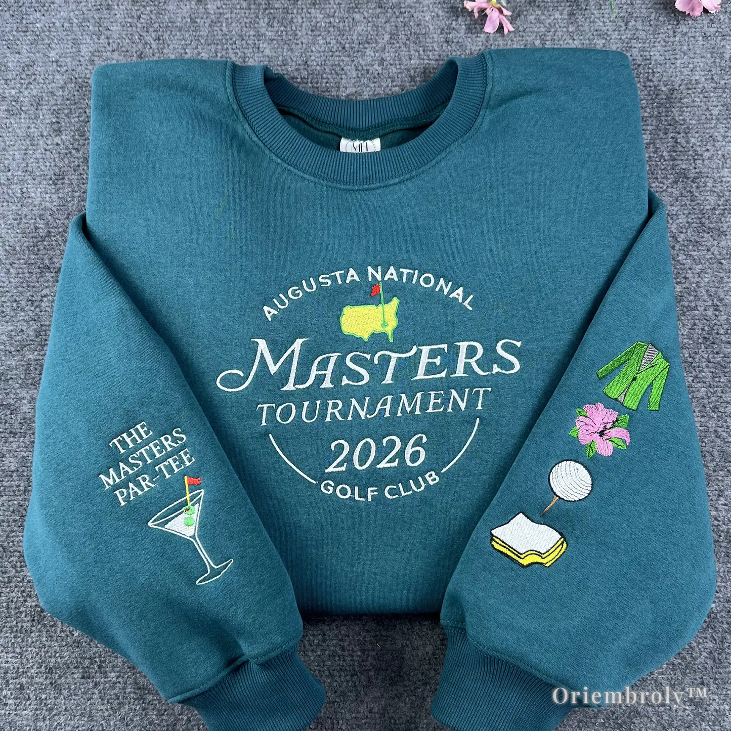 Premium teal crewneck sweatshirt featuring high-quality Masters Tournament 2026 Augusta National embroidery. A must-have souvenir for golf fans and tournament enthusiasts