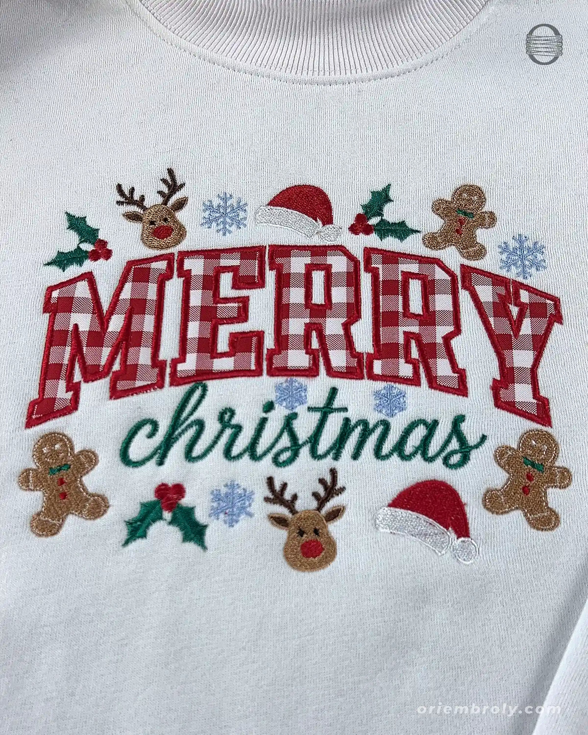 Close-up of red plaid Merry Christmas embroidery surrounded by cute holiday icons on a white sweater