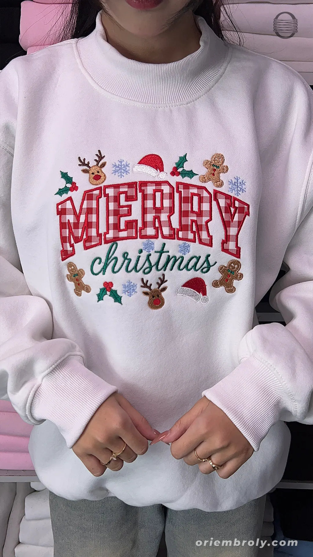 Overview of a white holiday embroidered crewneck sweater with plaid text and winter festive details