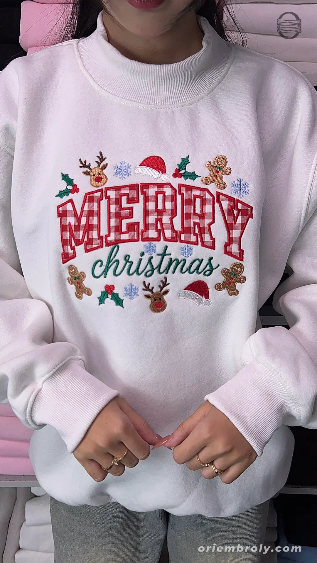 Overview of a white holiday embroidered crewneck sweater with plaid text and winter festive details