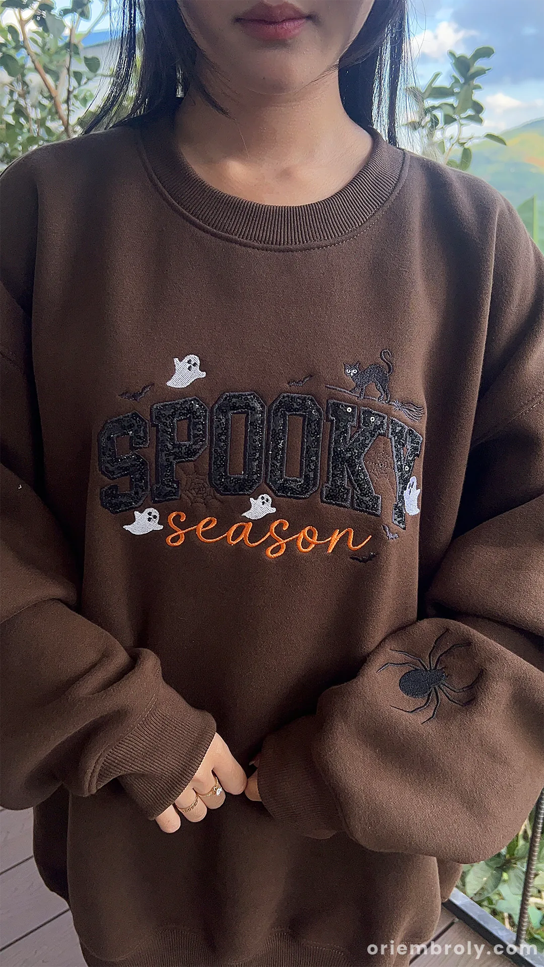 Model wearing cozy dark brown spooky season embroidered sweatshirt for fall and halloween season in US.