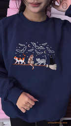 Model wearing a navy blue Halloween crewneck sweater embroidered with cats riding a magic broomstick