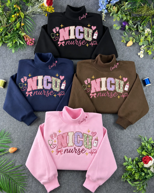 Flat lay display of NICU nurse embroidered crewneck sweatshirts in black, navy blue, chocolate brown, and light pink colors