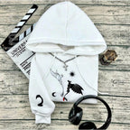 White hoodie with black designs on a wooden surface with headphones and a clapboard.