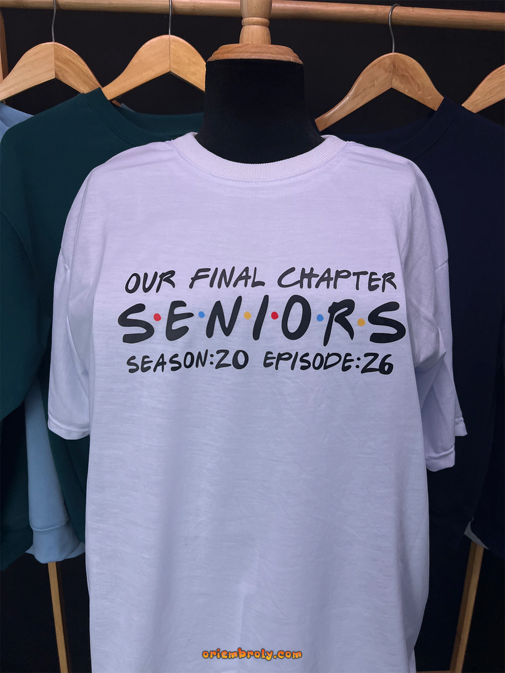 White t-shirt with 'Our Final Chapter Seniors' text on a mannequin against a dark background.