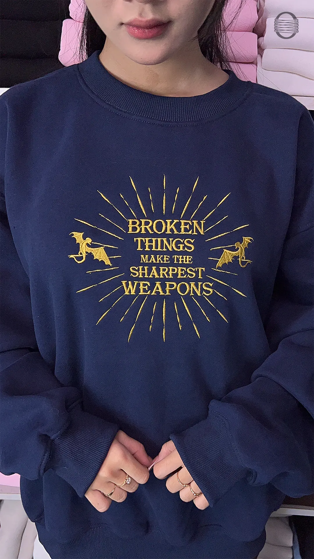 Model wearing an oversized navy blue Broken Things Make The Sharpest Weapons embroidered crewneck sweater for bookish outfit