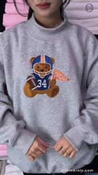 Model wearing an oversized sport grey Chicago football bear number 34 embroidered crewneck sweater for game day outfit