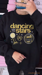Model wearing an oversized black Dancing with the Stars embroidered crewneck sweater for pop culture outfit