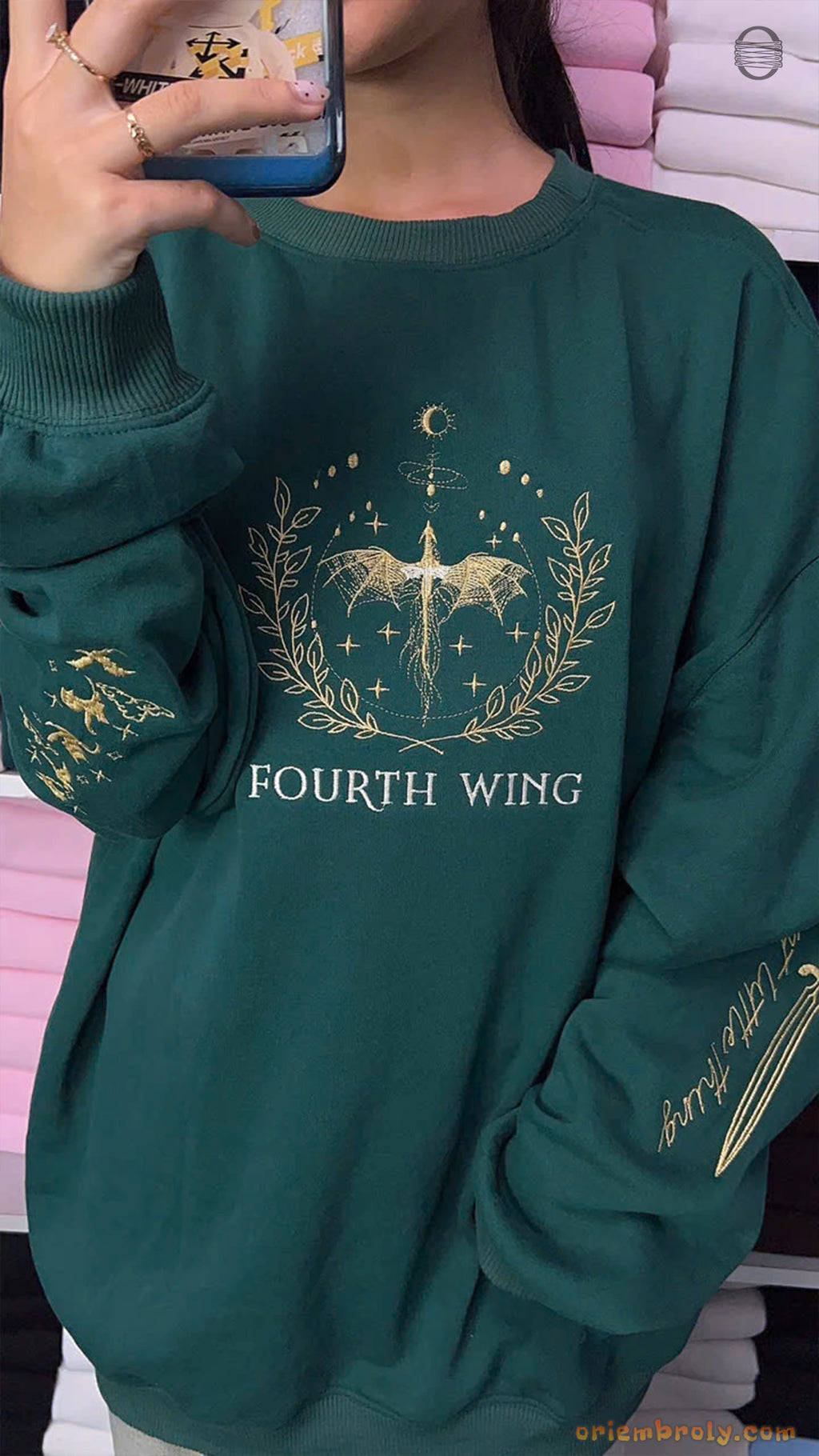 Model wearing an oversized forest green Fourth Wing crewneck sweater with gold dragon and sword sleeve embroidery