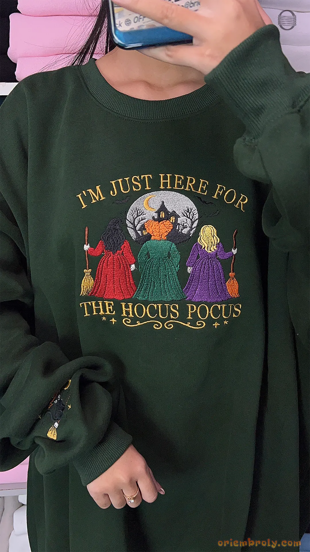 Model wearing an oversized forest green Im Just Here For The Hocus Pocus embroidered sweatshirt
