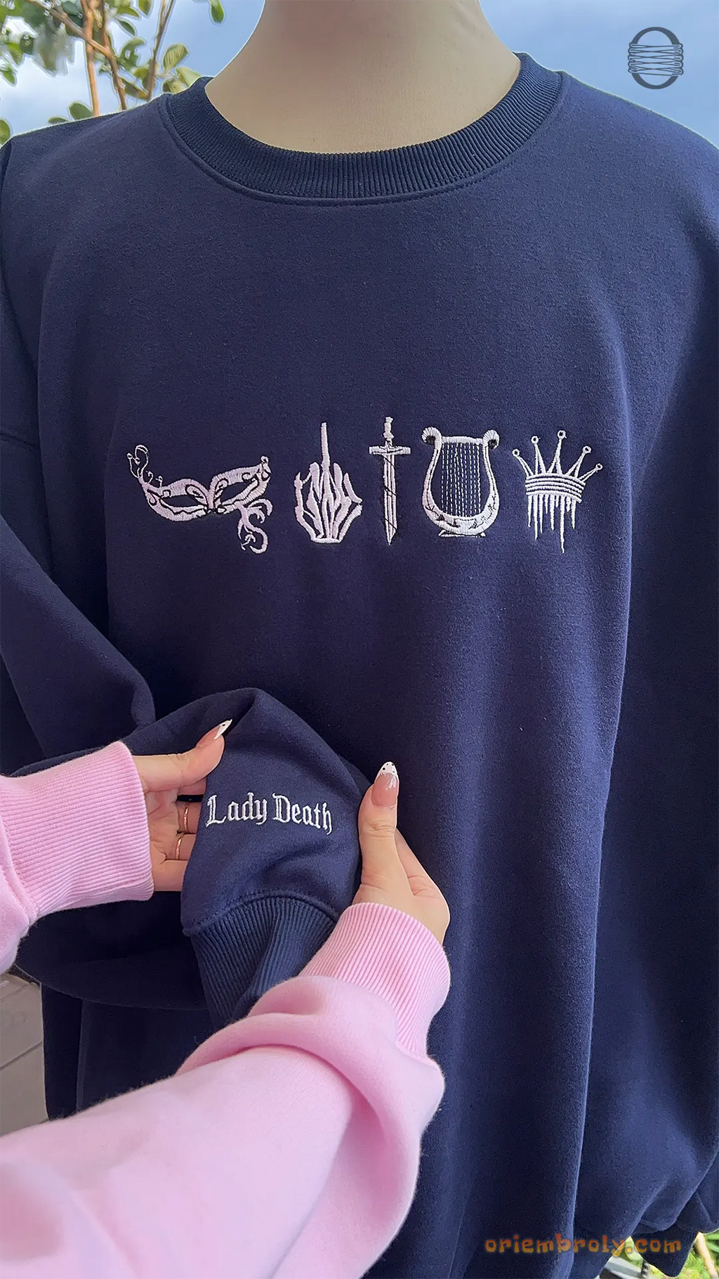 Model wearing an oversized navy blue Lady Death embroidered crewneck sweater showing chest and sleeve embroidery